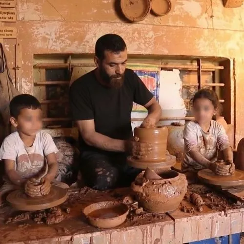 Traveling to Morocco with Kids: A traditional artisan teaching two young tourists some pottery-making skills