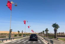 Driving in Morocco on a wide boulevard lined with Moroccan flags in Laayoune