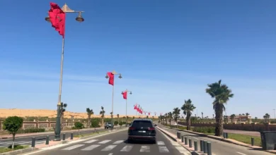 Driving in Morocco on a wide boulevard lined with Moroccan flags in Laayoune