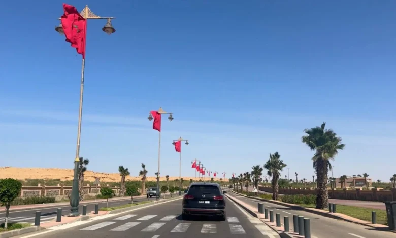 Driving in Morocco on a wide boulevard lined with Moroccan flags in Laayoune