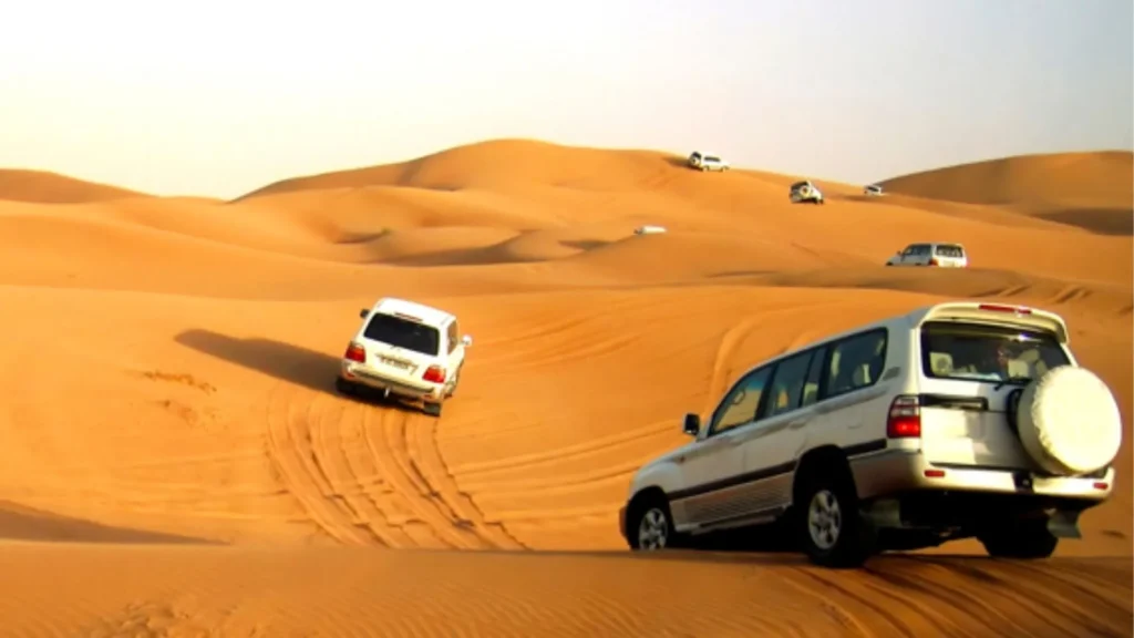 4x4 vehicles navigating the golden sand dunes during a desert safari in the Moroccan Sahara