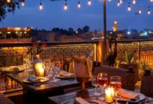 Can you drink alcohol in Morocco — rooftop restaurant in Marrakech with wine glasses and candlelight overlooking the medina at night