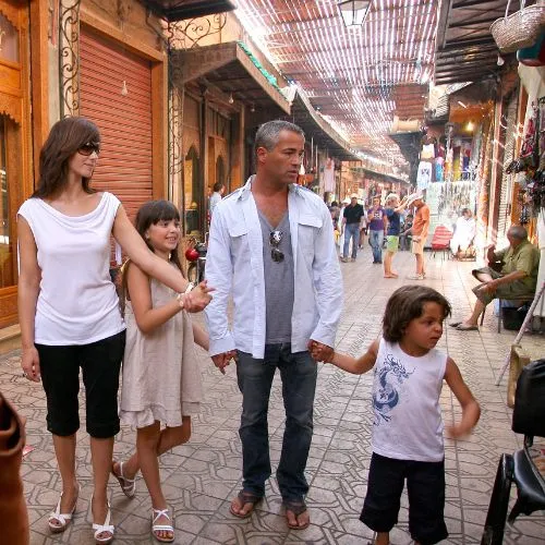 Family with children walking through a traditional souk in Marrakech, demonstrating that Morocco is safe for Americans with kids and welcoming to families.