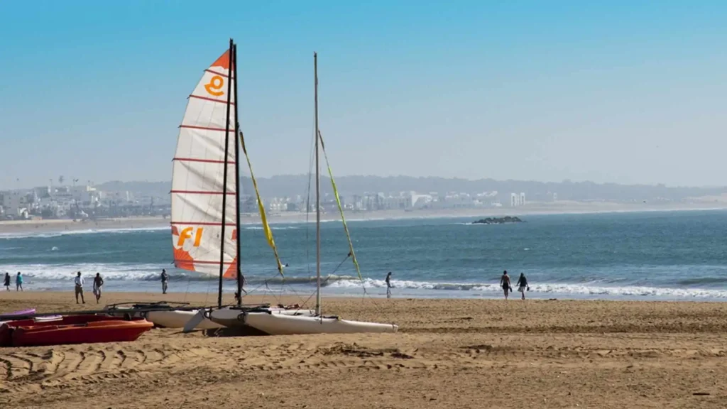 Sailboats and beachgoers on Agadir's Atlantic coast — the best time to visit Morocco's beaches runs from June through September