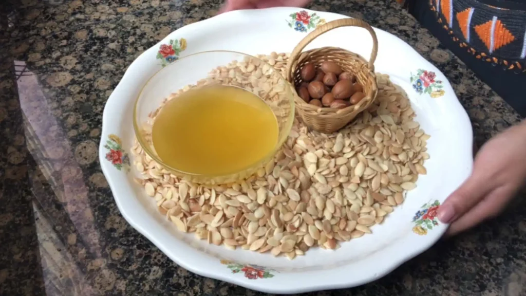 Fresh argan oil in a glass bowl surrounded by argan seeds — the most iconic product on any what to buy in Morocco list