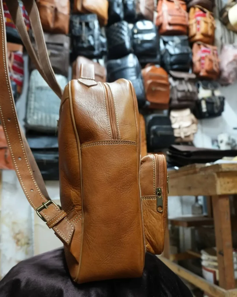 Handmade Moroccan leather backpack in a Fez workshop — leather goods are among the most popular choices for what to buy in Morocco
