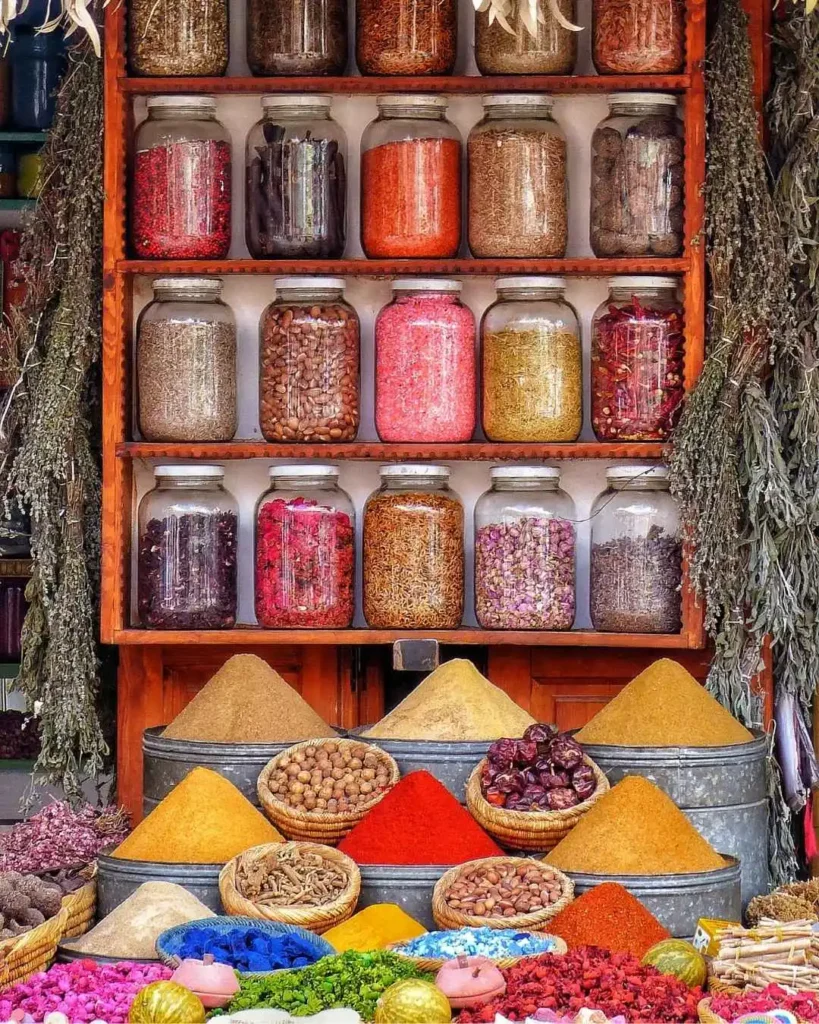 Colorful spice pyramids and jars of dried herbs at a Moroccan souk — spices are among the top picks for what to buy in Morocco