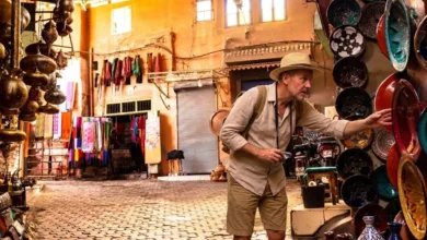 What to buy in Morocco — a traveler browsing handcrafted ceramics and lanterns in a Moroccan souk