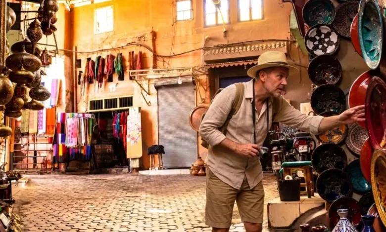 What to buy in Morocco — a traveler browsing handcrafted ceramics and lanterns in a Moroccan souk