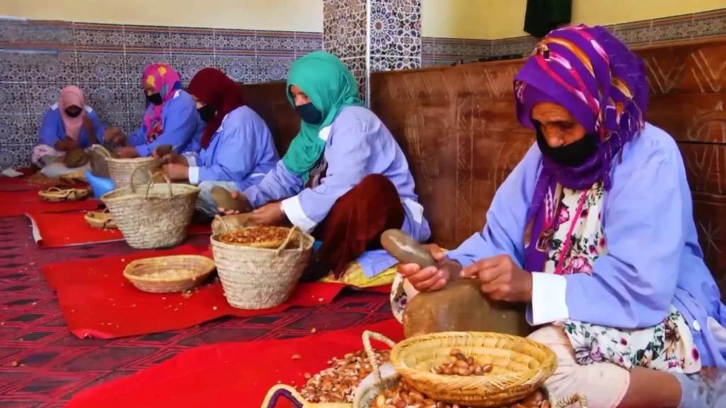 Women cracking argan nuts at a cooperative in southern Morocco — one of the best places to buy authentic argan oil when deciding what to buy in Morocco