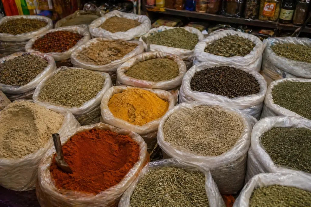 Moroccan spices including paprika, turmeric, cumin and dried herbs displayed in open sacks at a traditional medina spice market