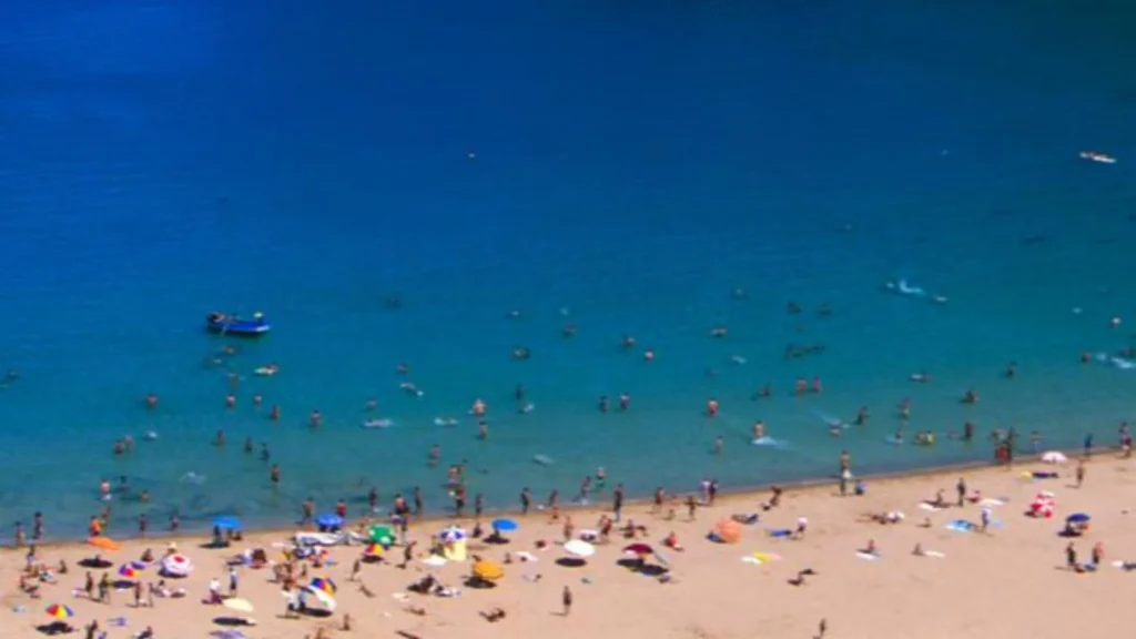 Beachgoers swimming in the turquoise Mediterranean waters of Al Hoceima, one of the best north Morocco beaches
