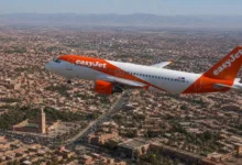 EasyJet Airbus A319 flying over Marrakech with the Koutoubia Mosque and Atlas Mountains visible, illustrating the new Strasbourg-Marrakech direct flight