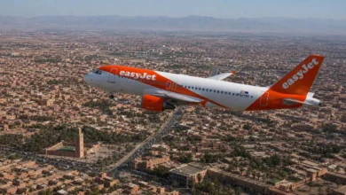 EasyJet Airbus A319 flying over Marrakech with the Koutoubia Mosque and Atlas Mountains visible, illustrating the new Strasbourg-Marrakech direct flight