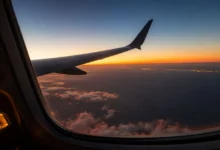 View of the Moroccan coastline at sunrise from the window of a transatlantic aircraft, illustrating the experience of flights to Morocco from NYC.